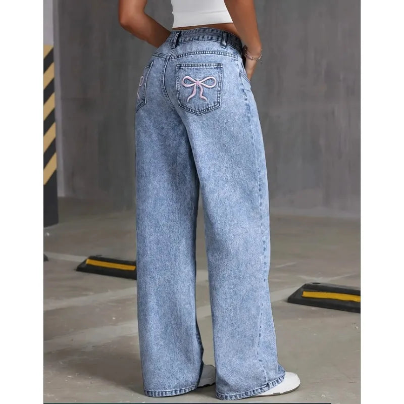 A jean that combines comfort and style. With a wide leg and high waist cut, these jeans elongate the silhouette. The delicate embroidered bows on the pockets add a modern and feminine touch, perfect for a casual look full of personality.