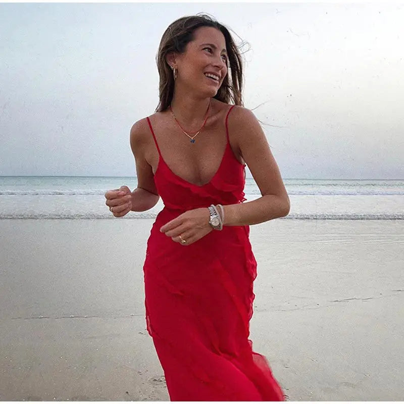 A summer classic. This long chiffon dress is pure charm and lightness, with thin straps and ruffles that give a sexy and romantic touch. The perfect fit for any occasion under the sun.